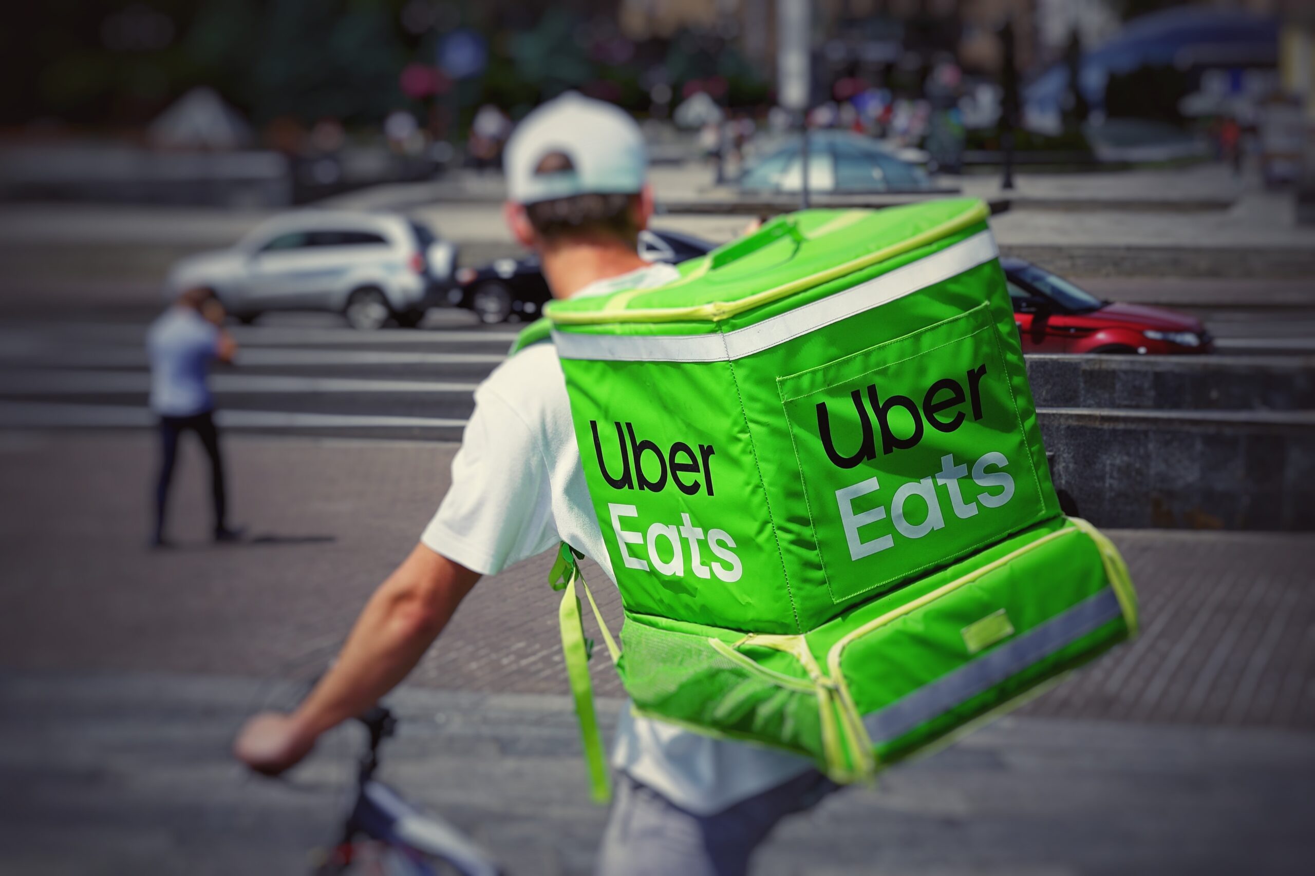 Uber Eats courier riding bike with green backpack