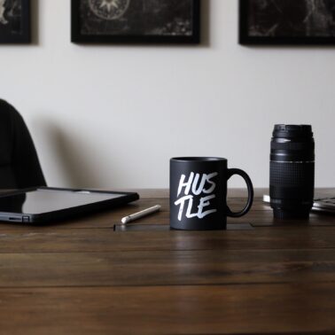 Black coffee mug sitting on a wood desk